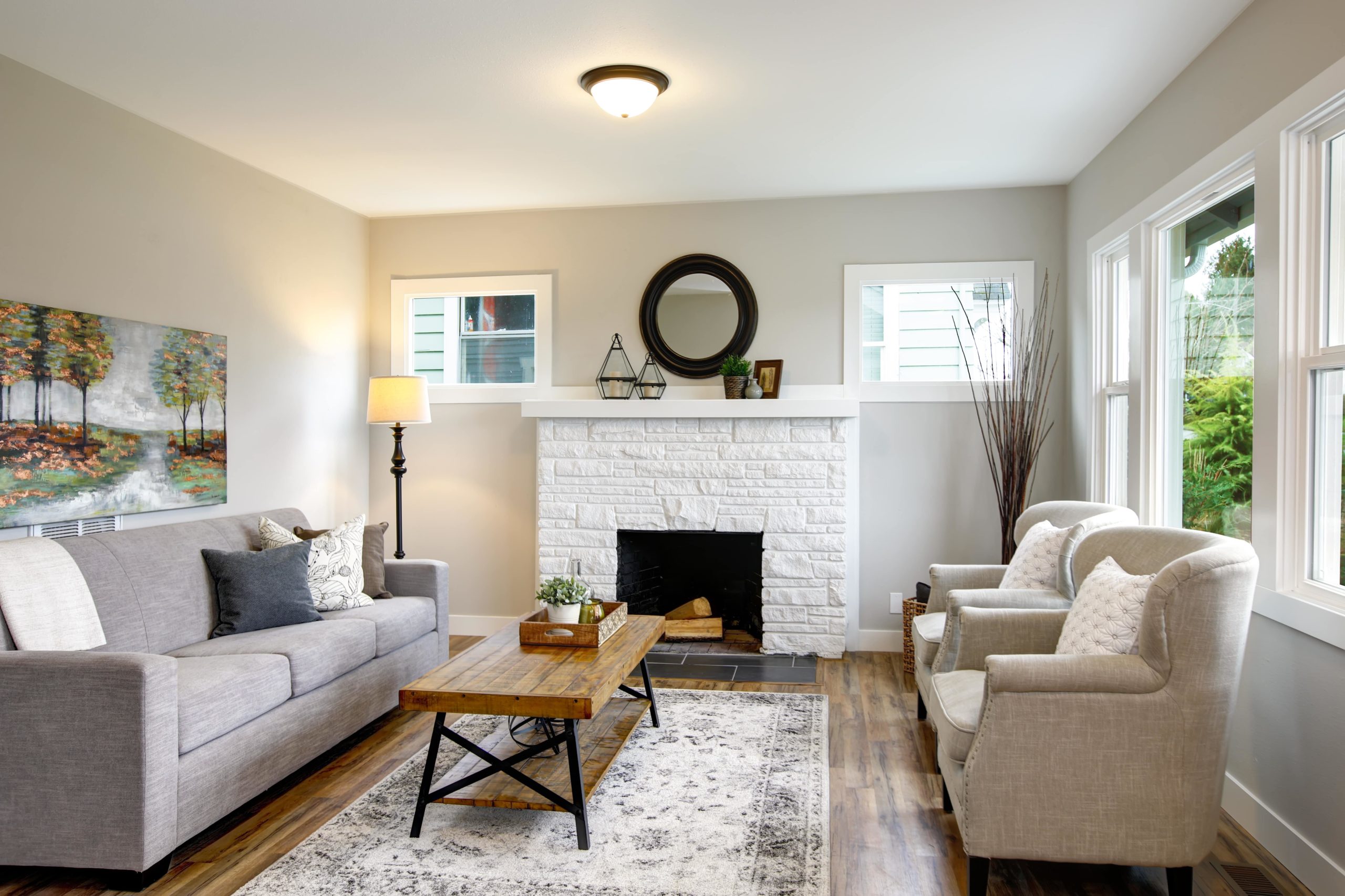 A beautiful white living room with rustic accents, complete with white stone fireplace